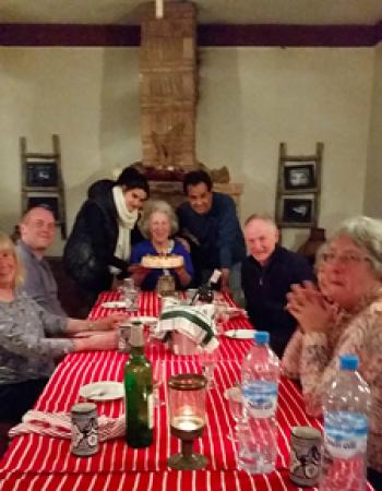 Edna R.S. Alvarez (center), flanked by the chef de cuisine and the guest house owner, receiving a cake for her 78th birthday —  Sel d’Ailleurs.